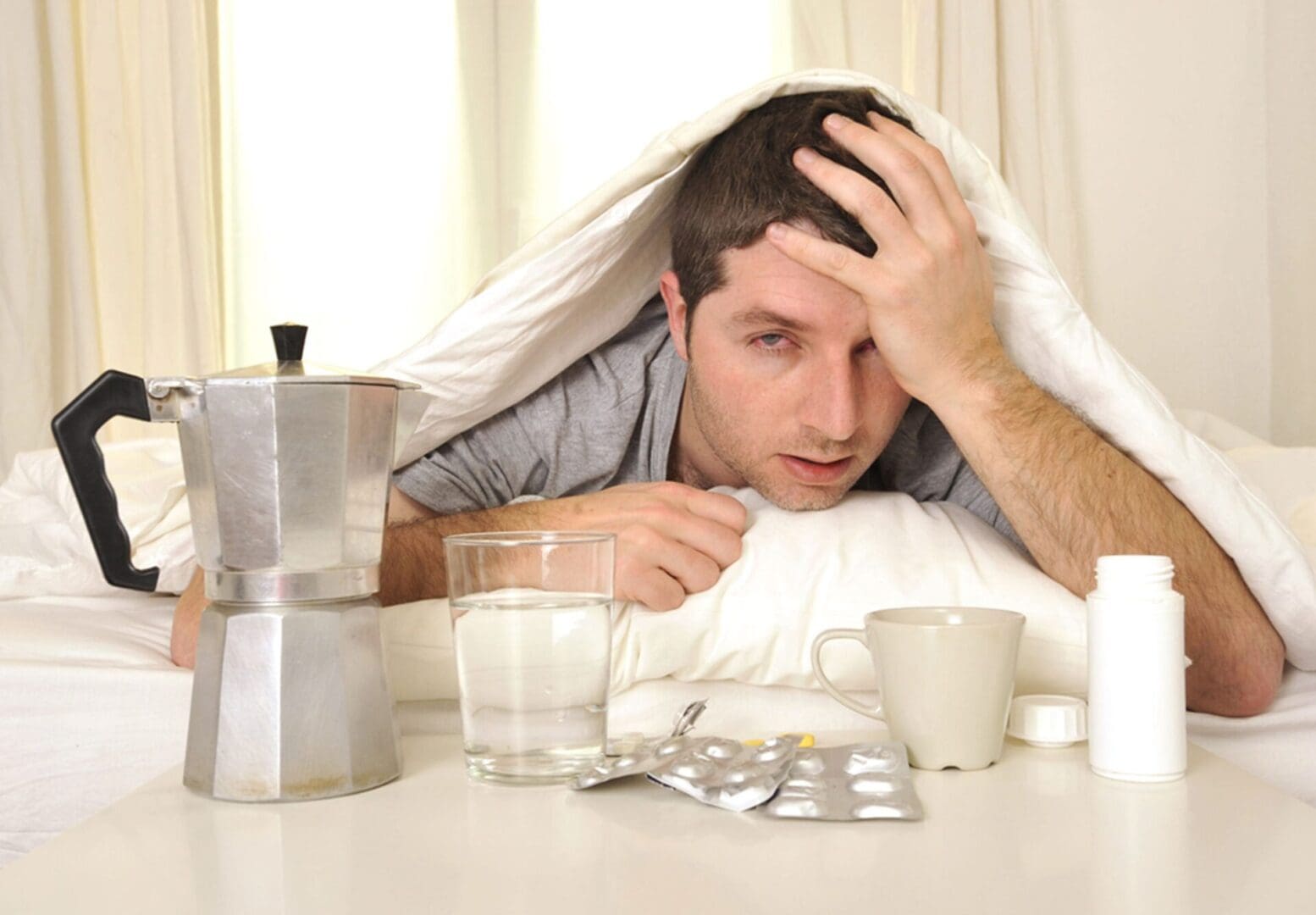 A man laying in bed with his head on the table