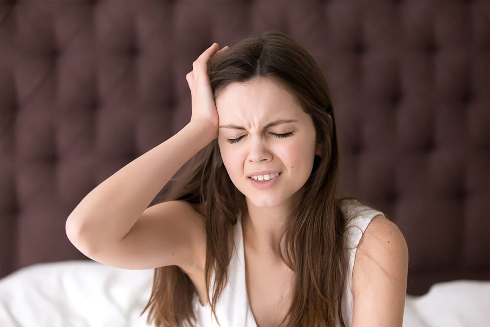 A woman is holding her head in frustration.